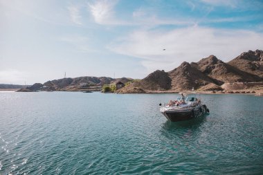 Mayo giymiş kızlar güneşleniyor. Kızlar denizde bir yatta dinleniyorlar.