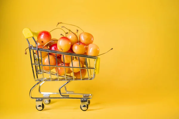 Carrinho Supermercado Com Cerejas Amarelas Fundo Amarelo — Fotografia de Stock