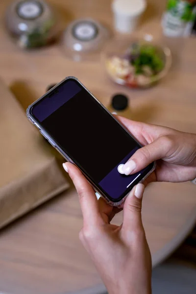 a black smartphone in female hands. phone template.