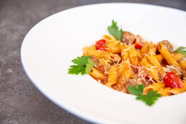 Beyaz tabakta otlu makarna.