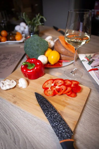 knife and ingredients on a wooden plank for cooking.