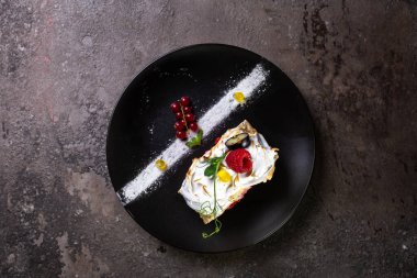 Siyah bir tabakta taze ahududulu yumuşak rulo..