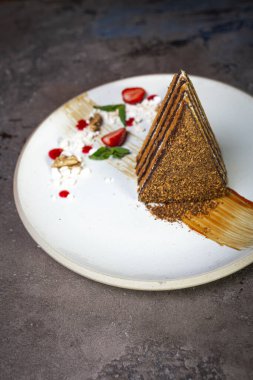 Bir restoranda tatlı servis eden beyaz bir tabakta ballı kek..