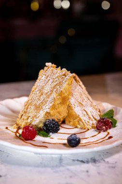 Beyaz tabakta böğürtlenli Napolyon keki. Lokantada tatlı servisi..