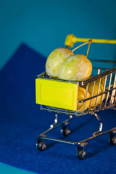 Plums Small Supermarket Cart Blue Background — Stockfoto