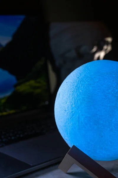 Moon lamp on the desktop in a dark room.
