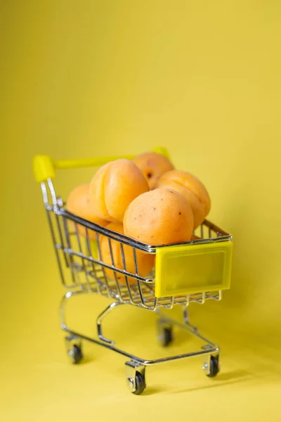 Apricots Small Shopping Cart Yellow Background — Stockfoto