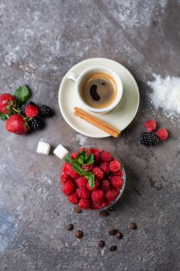 top view dessert with fresh raspberries and a cup of coffee on a concrete background.