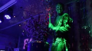 A drummer in a suit plays the drums.