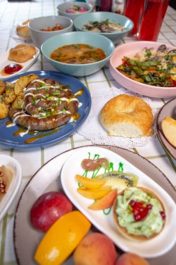 Yemek masasında patates ve farklı tabaklar bulunan ev yapımı sosisler.