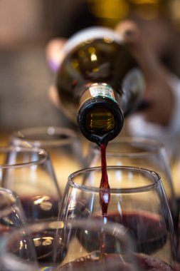 Bir şişeden kırmızı şarap şişeleniyor..