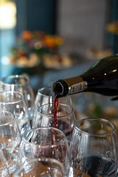 Bir şişeden kırmızı şarap şişeleniyor..