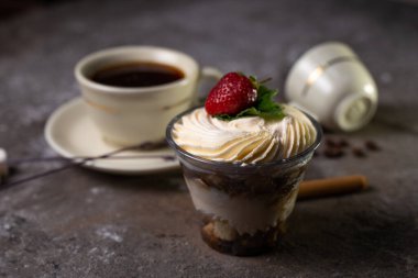 Çilekli bir bardak tatlı ve bir fincan çay..