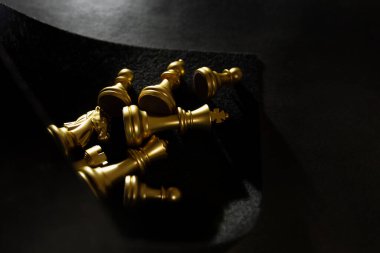 Siyah arkaplan görünümlü altın satranç taşları.