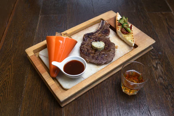 whiskey and steak with sauce on wood