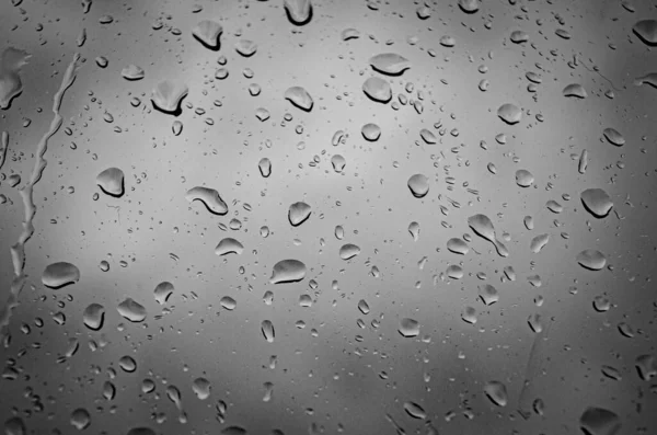 Foto oscura de gotas de lluvia en una ventana —  Fotos de Stock