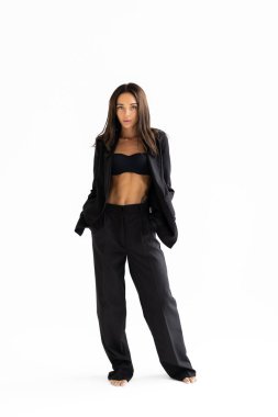 Beyaz arka planda poz veren gülümseyen çekici iş kadınının tam boy portresi.