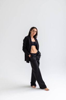 Siyah sütyen giyen seksi bir kadın. Beyaz arka planda takım elbisesi var..