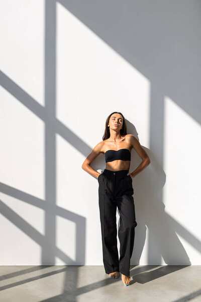 Elegant young business woman after work, posing over black background.