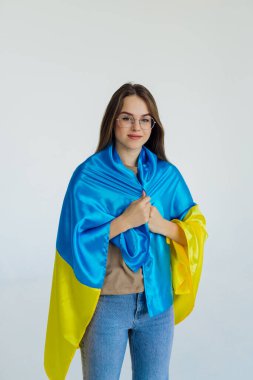 Beyaz arka planda Ukrayna bayrağı olan güzel genç bir kadın.