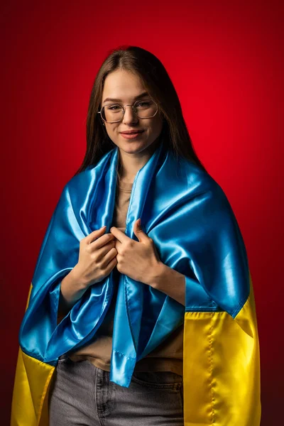 Ung Kvinna Med Ukraina Nationell Flagga Står Röd Bakgrund — Stockfoto