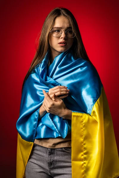 Ung Kvinna Täckt Med Ukraina Nationella Flagga Över Röd Bakgrund — Stockfoto