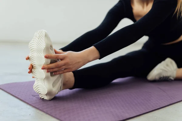 Fit Woman Stretching Her Leg Warm White Background — Foto de Stock