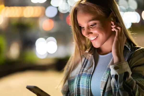 Lachende Jonge Vrouw Wandelen Stad Nachts Met Een Koptelefoon Genieten — Stockfoto