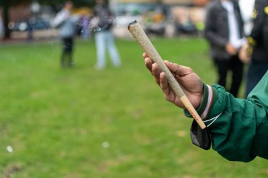 A man's hand holds a giant marijuana RAW cigarette during the 420 commemoration in Bogota