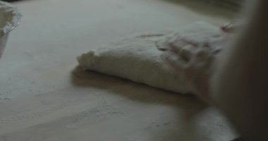 Dişi bir fırıncı ekmek pişirmek için ekmek hamuru yoğurur..