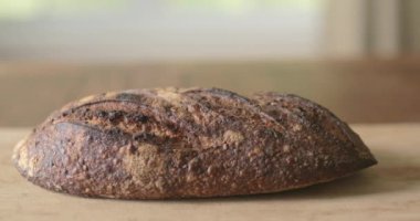 Taze bir somun ekmek kesme tahtasının üzerinde duruyor..