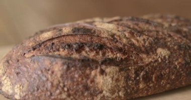 Taze bir somun ekmek kesme tahtasının üzerinde duruyor..