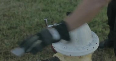 İtfaiyeci eğitim sırasında yangın musluğu açar.