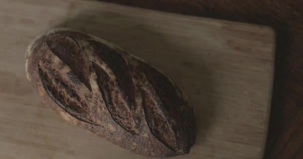 Ein Frischer Laib Handwerkliches Brot Sitzt Auf Einem Schneidebrett — Stockvideo