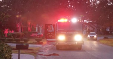 Yangın sırasında kırmızı itfaiye aracı eve park etmiş.