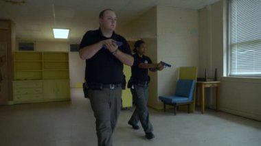 Bir grup polis, okuldaki silahlı çatışmalara müdahale etmek için silah çekilen odaları boşaltıyor..