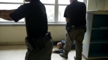 Bir grup polis, okuldaki silahlı çatışmalara müdahale etmek için silah çekilen odaları boşaltıyor..