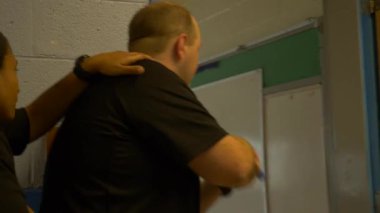 Bir grup polis, okuldaki silahlı çatışmalara müdahale etmek için silah çekilen odaları boşaltıyor..