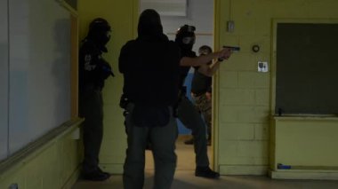 Bir grup polis, okuldaki silahlı çatışmalara müdahale etmek için silah çekilen odaları boşaltıyor..