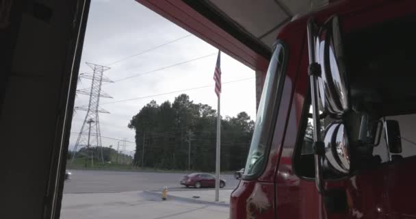 手前に消防車のある消防署の外のアメリカ国旗 — ストック動画