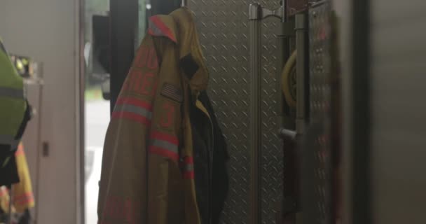 Ein Feuerwehrmantel Hängt Einem Einsatzbereiten Feuerwehrauto — Stockvideo