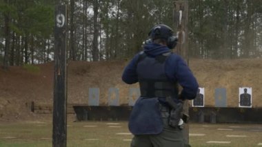 Polis memuru atış talimi sırasında poligonda duruyor..