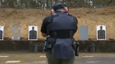Polis, atış talimi sırasında tüfeğiyle atış poligonunda yürür..