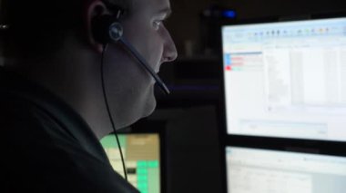 Bir 911 memuru, acil aramalara cevap vermek için kontrol merkezindeki bilgisayar istasyonunda çalışıyor..