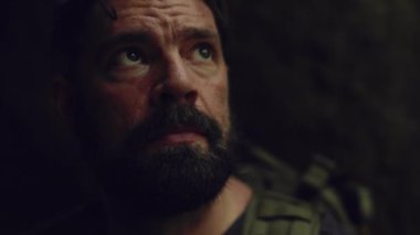 Dışarıda fırtınadan yıldırım çakarken, bir erkek yürüyüşçünün mağarada oturduğu el kamerası görüntüsü..