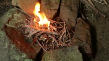 Dallardan yapılmış küçük bir kamp ateşinin el kamerası görüntüsü..