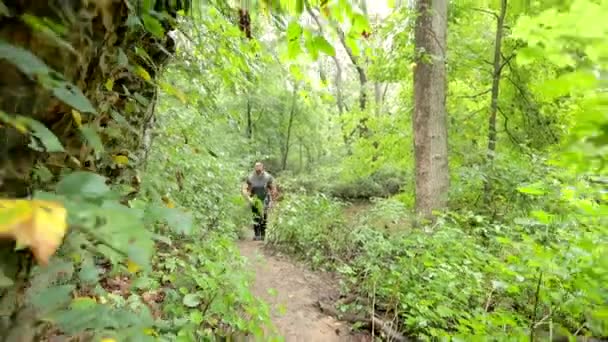 Hombre Camina Con Una Mochila Largo Sendero Través Bosque Espeso — Vídeo de stock