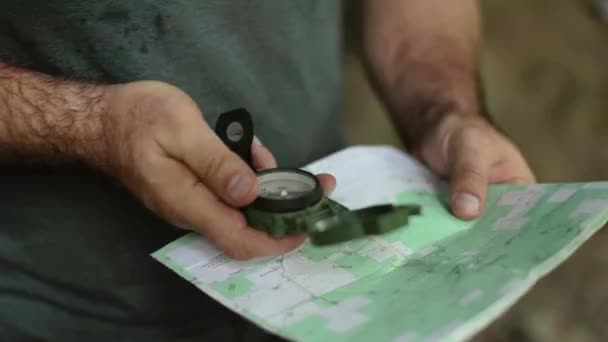 Ręczne Ujęcie Mężczyzny Używającego Magnetycznego Kompasu Soczewkowego Topograficzna Mapa Wędrówek — Wideo stockowe
