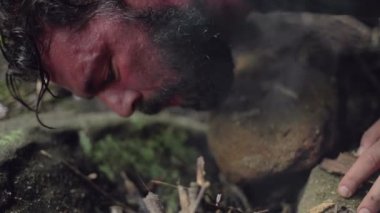 Erkek bir kampçı, yavaş çekimde başlamak için küçük bir kamp ateşine üfledi..