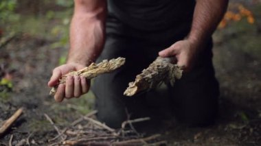 Erkek bir kampçı sopayı yavaş çekimde tutuşturmak için kırar..